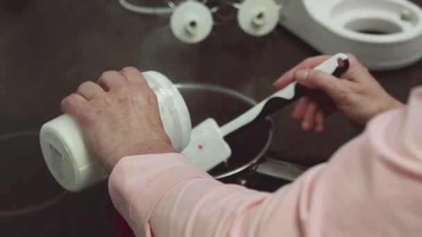 Women hand puts powdered sugar into pan with simmering berries and fruits — Stock Video