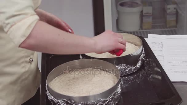 Cocinera de pastelería femenina que usa espátula de hielo para alisar la masa en el plato para hornear — Vídeos de Stock