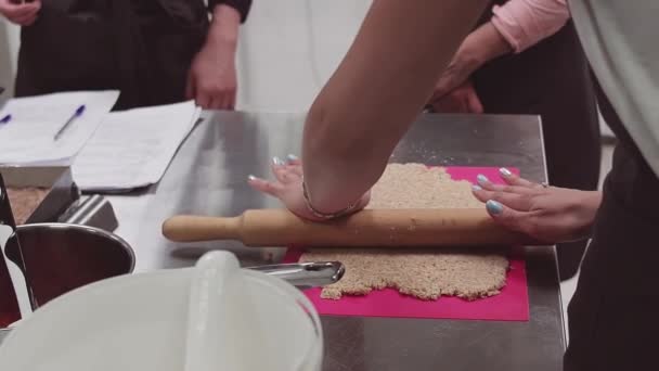 Handen van chef-kok met deegroller op deeg op roze snijplank bakken — Stockvideo