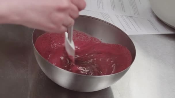 La mano del chef de pastelería revuelve la crema de fruta de bayas rojas en el tazón — Vídeo de stock