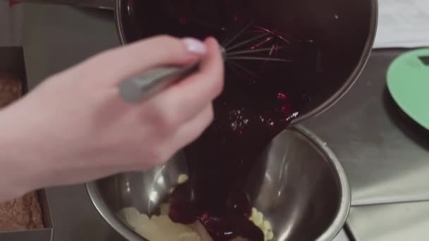 Chef de pastelaria derrama bagas vermelhas em panela de metal usando batedor na cozinha — Vídeo de Stock