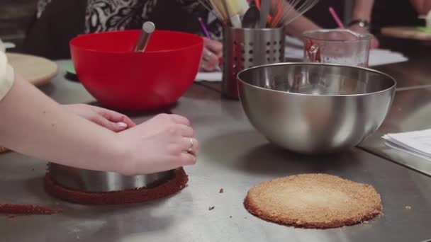 Vrouwelijke banketbakker handen bezuinigingen shortcake bisquit met behulp van de ovenschaal — Stockvideo