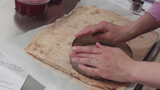 Vrouwelijke gebak chef-kok handen bezuinigingen shortcake bisquit met behulp van de ovenschaal — Stockvideo