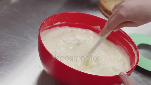 La mano femenina agita la crema blanca acuosa en el tazón de la cocina — Vídeo de stock