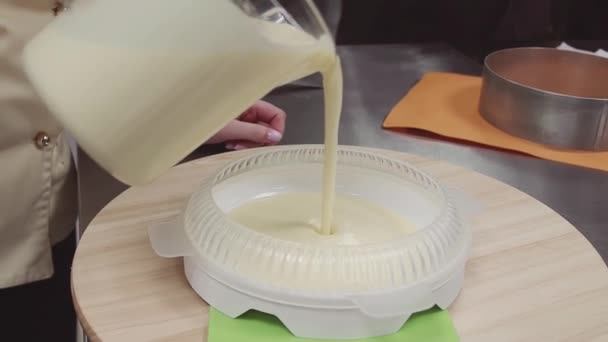 Crema natillas se vierte en forma de plato de plástico en la cocina pastelería — Vídeos de Stock