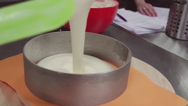 Custard creme pours into metal circle form at patisserie kitchen — Stock Video