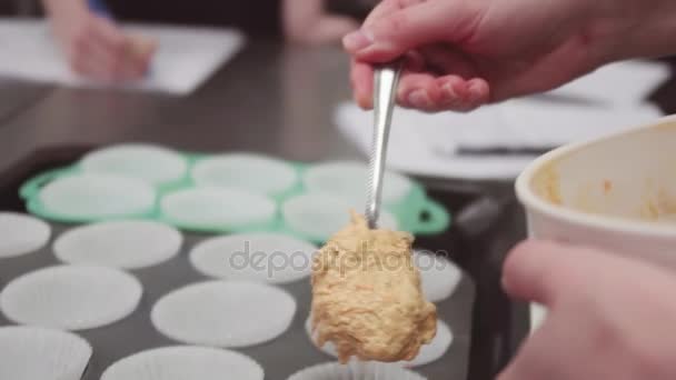 Pastelería mano chef pone la masa en magdalenas papel pergamino tazas en bandeja para hornear — Vídeo de stock