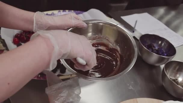 デザート料理手が金属ボウルに溶かしたチョコレートをかき立てる — ストック動画