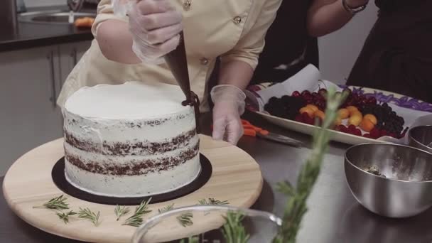 Pastelera hembra decora pastel de esponja con chokolate derretido — Vídeo de stock