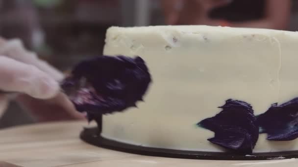 Gebak chef-kok hand vlekken paarse crème op Witte icing spons crème — Stockvideo
