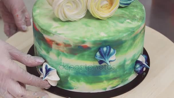 Confectioner hands decorates colorful sponge cake with merengues — Stock Video