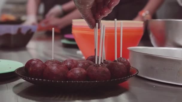 Konfeksi tangan menempatkan tongkat dalam coklat adonan bola makanan penutup — Stok Video