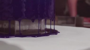 Mavi ayna sır damlama kapalı kek mutfak masasının üzerine krema