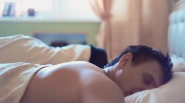 Kaslı adam yatakta kız arkadaşıyla sabahın erken saatlerinde uyuyor.