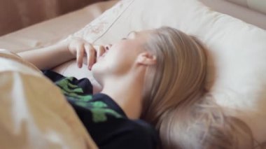 Sabahın erken saatlerinde yatakta yatan çekici tembel sarışın kadın