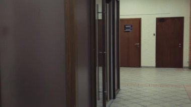 Genç çekici kadın açık cam dor ve yürüyüşlere office koridor içine