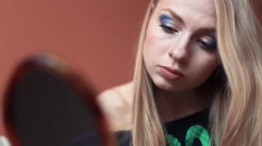 Çekici kadın onu yapmak yapıyor üzerinde mavi göz gölgeler koyar