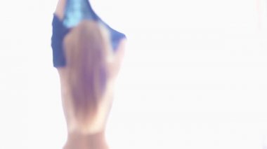 Parlak pencerenin önünde kıyafet değiştirerek genç seksi kadın silüeti