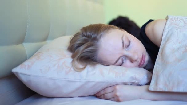 Mladá spící žena mračí v posteli v časných ranních hodinách