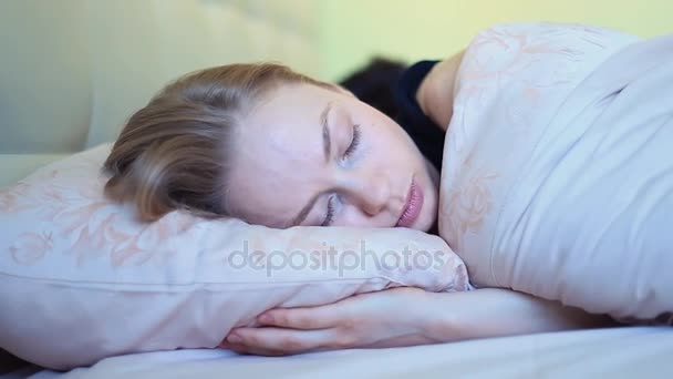 Mujer joven con ojos azules habla con el marido acostado en la cama por la mañana temprano — Vídeos de Stock