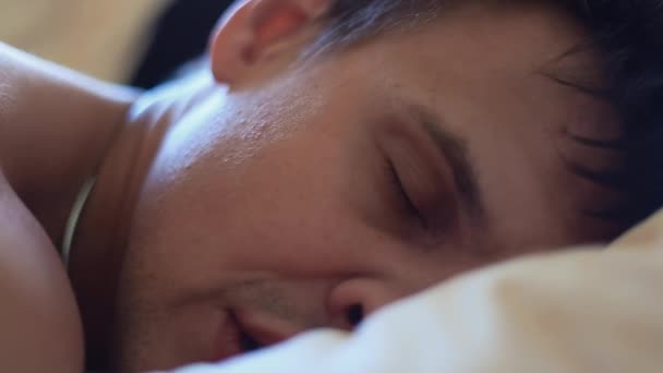 Uomo muscolare che dorme a letto faccia sul cuscino al mattino presto — Video Stock