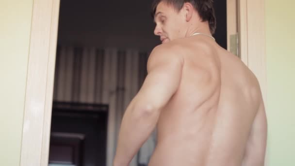 Mocny człowiek stawia na spodnie w wcześnie rano w sypialni — Wideo stockowe
