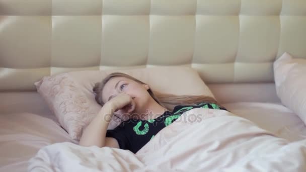 Довольно ленивая блондинка вылезает из постели рано утром — стоковое видео