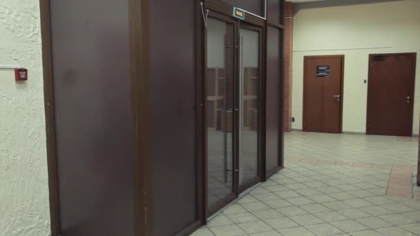 Genç çekici kız açık cam dor ve yürüyüşlere office koridor içine — Stok video