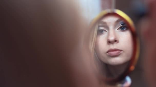 Reflexão de mulher atraente fazendo sua maquiagem coloca no rímel olhando — Vídeo de Stock