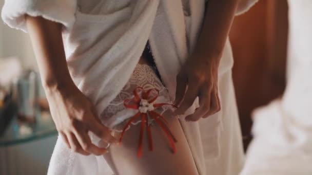 Young bride girl standing in room posing for photo with garter — Stock Video