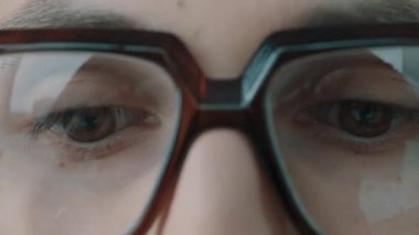 Yan yana sallayarak büyük kemik çerçeveli gözlüğü gözlerine hızlandırılmış hareket