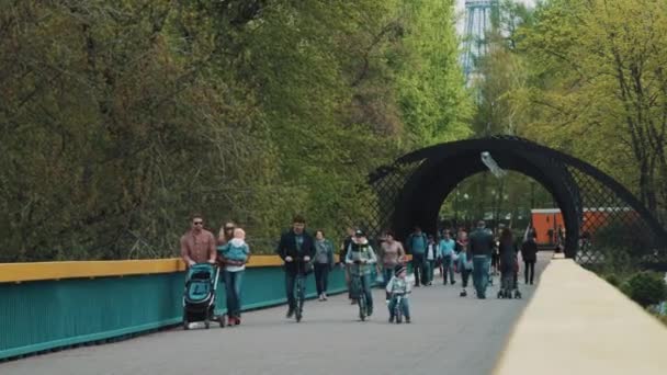 MOSCÚ, RUSIA - 20 DE JUNIO DE 2016: Personas con niños caminando por el puente en el área del parque recreativo de la ciudad — Vídeo de stock