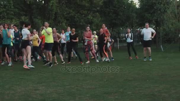Moscow, Federacja Rosyjska - 20 czerwca 2016: Tłum ludzi fitness robi strony skacze w city park zielony trawnik — Wideo stockowe