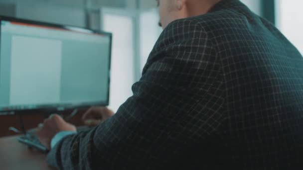 Büroangestellter in karierter Jacke tippt müde auf Computertastatur — Stockvideo