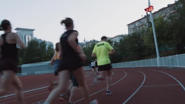 MOSCOW, RUSSIA - JUNE 20, 2016: Løpere som jogger på utendørs stadion i bysovesal i sum – stockvideo