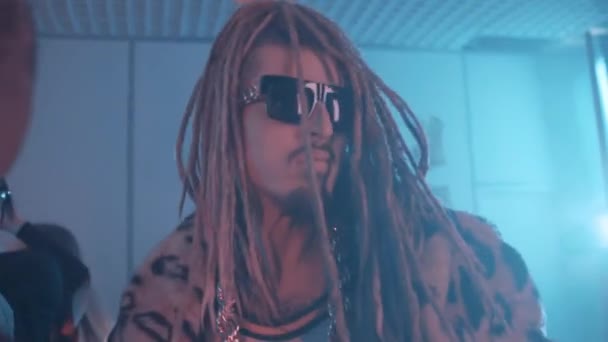 Man med dreadlocks och leopard päls kappa dansa upp på rökt festlokal — Stockvideo