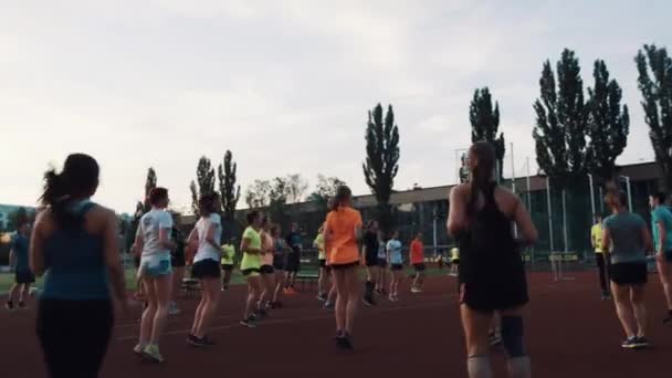 МОСКВА, РОССИЯ - 20 июня 2016 года: Спортивные люди толпы прыгают на месте, разогревая упражнения на s — стоковое видео