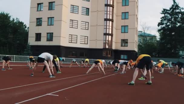 MOSCOW, RUSSIA - JUNI 20, 2016: Sportsfolk gruppetræning strækker sig tilbage, lave gynger fra siden – Stock-video