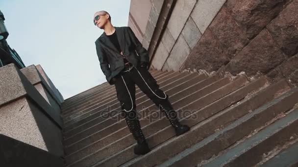 Androgynous queer calvo chica en rock traje pisar el pie fuera en la escalera — Vídeo de stock
