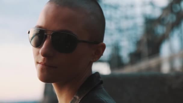 Androgyne queer chauve caucasien fille avec sourcil piercing regarder sur lunettes de soleil — Video