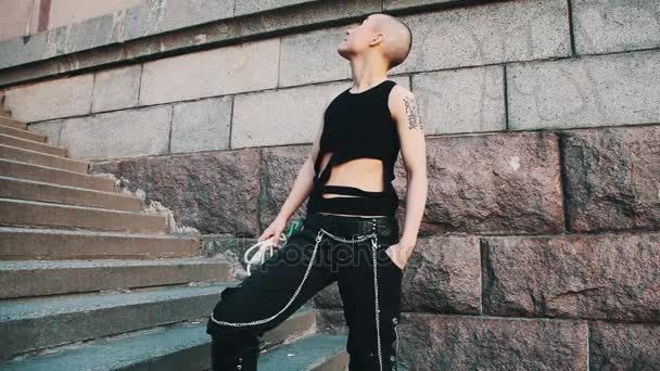 Androgyna queer skallig flicka i trasiga svart skjorta, hålla repet tittar upp trappan — Stockvideo