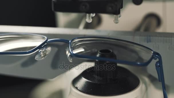 Mulher mão optimetritian em luvas brancas colocar lente redonda na máquina de medição — Vídeo de Stock
