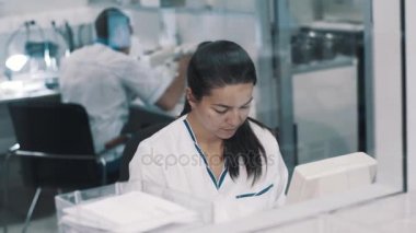 Kadın scinetist uyumak elbise laboratuvar cam arkasında çalışma içinde