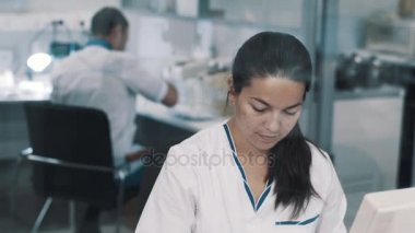 Kadın medician laboratuvar cam arkasında çalışan uyumak elbise içinde