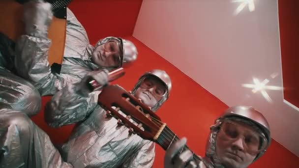 Trois hommes en salopette argentée, casquettes et lunettes jouant des instruments de musique — Video