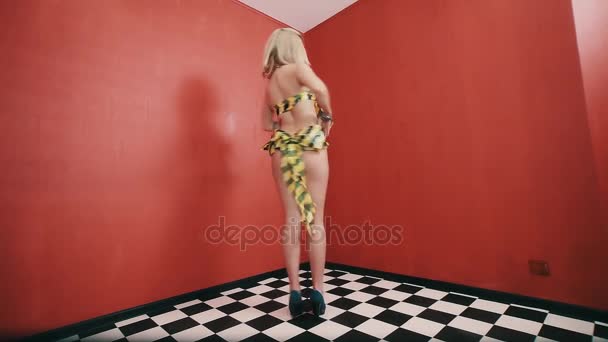 Sexy blonde girl in costume made out hazard tape dancing and talking — Stock Video