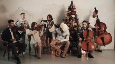 String quintet Noel süslemeleri ile odasında şarkıyı çalmaya şarkıcı ile