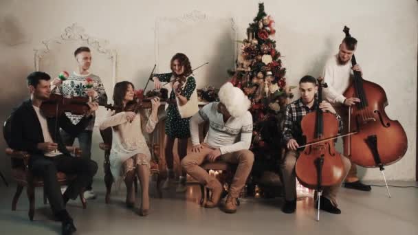 Quinteto de cordas com cantor tocando música no quarto com decorações de Natal — Vídeo de Stock