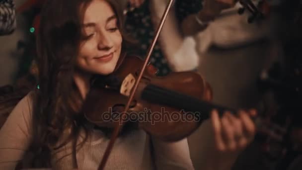 Mujer violinista linda tocando música en la habitación con decoraciones de Navidad — Vídeo de stock