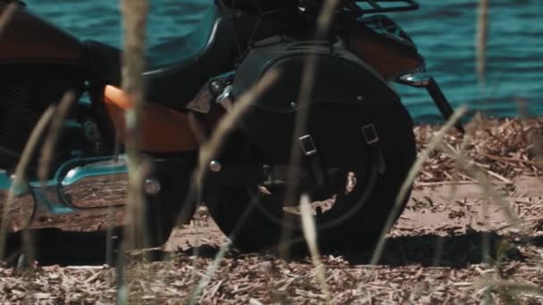 Motocicleta naranja de pie en la orilla del mar de arena — Vídeos de Stock